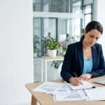 Consultant adding notes to a management system document