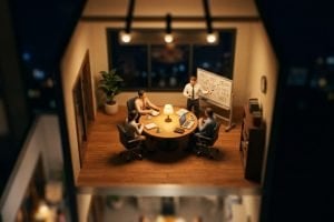 Tilt-shift miniature of an office meeting room at night, a small team working through a data breach response plan at a whiteboard