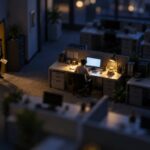 Tilt-shift miniature of an office at night, one figure at a lit desk and another in the doorway holding an envelope